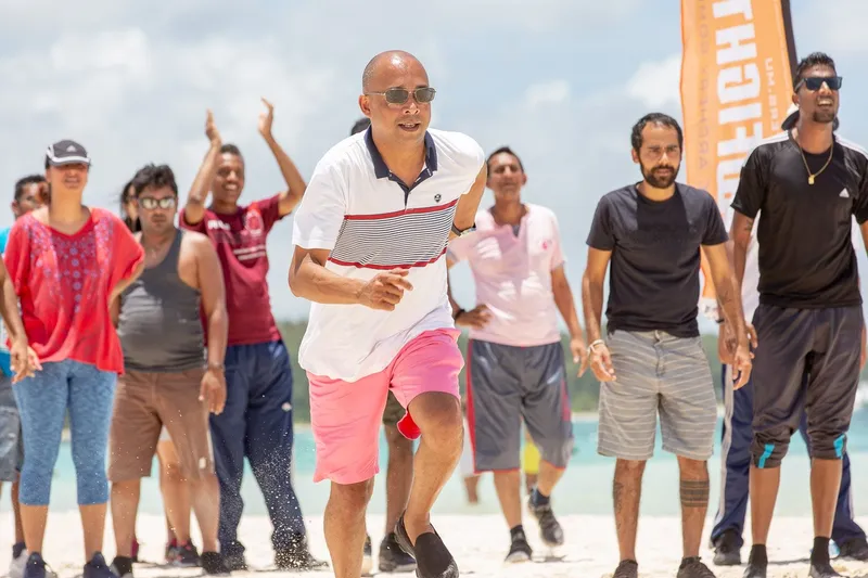 Beach sprint race with cheering crowd during team building event