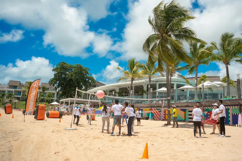 Panoramic view of team games at beach resort during team building
