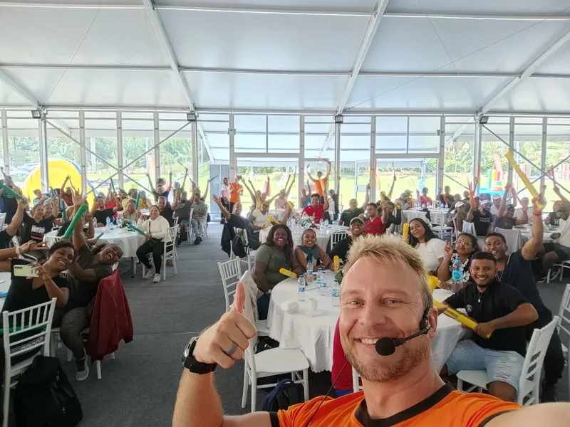 Corporate celebration with selfies and cheering crowd at marquee event